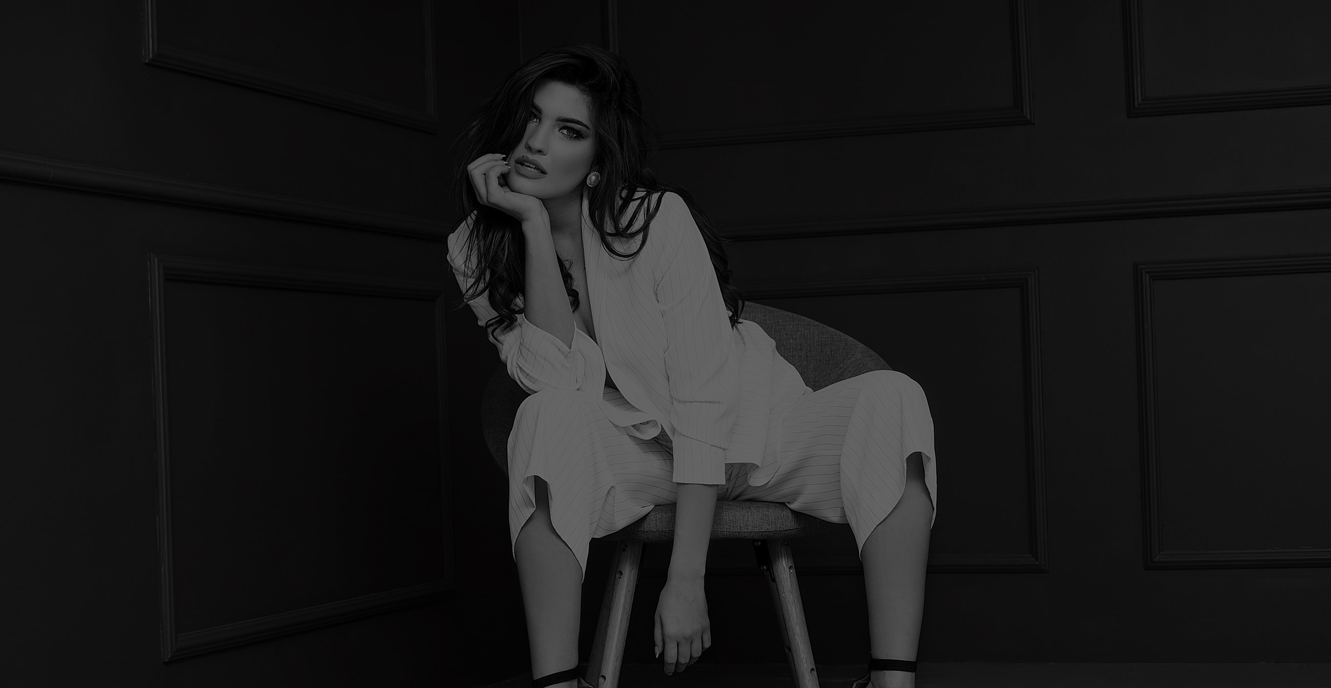 NYC plastic surgery model sitting elegantly in a modern interior.