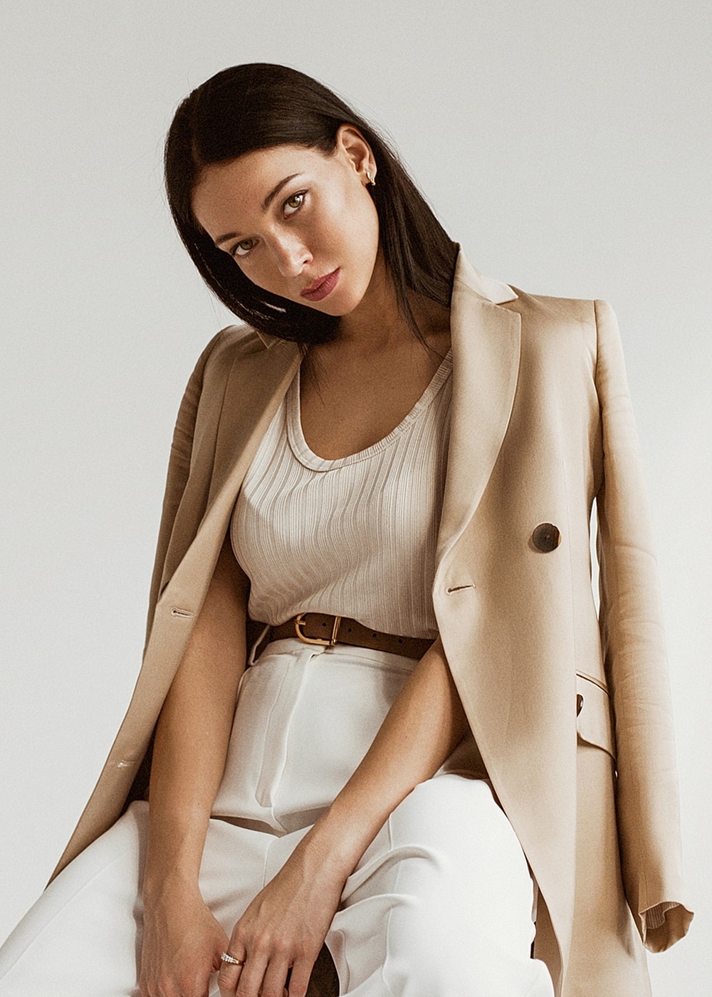 NYC plastic surgery model in stylish outfit with blazer and belt.