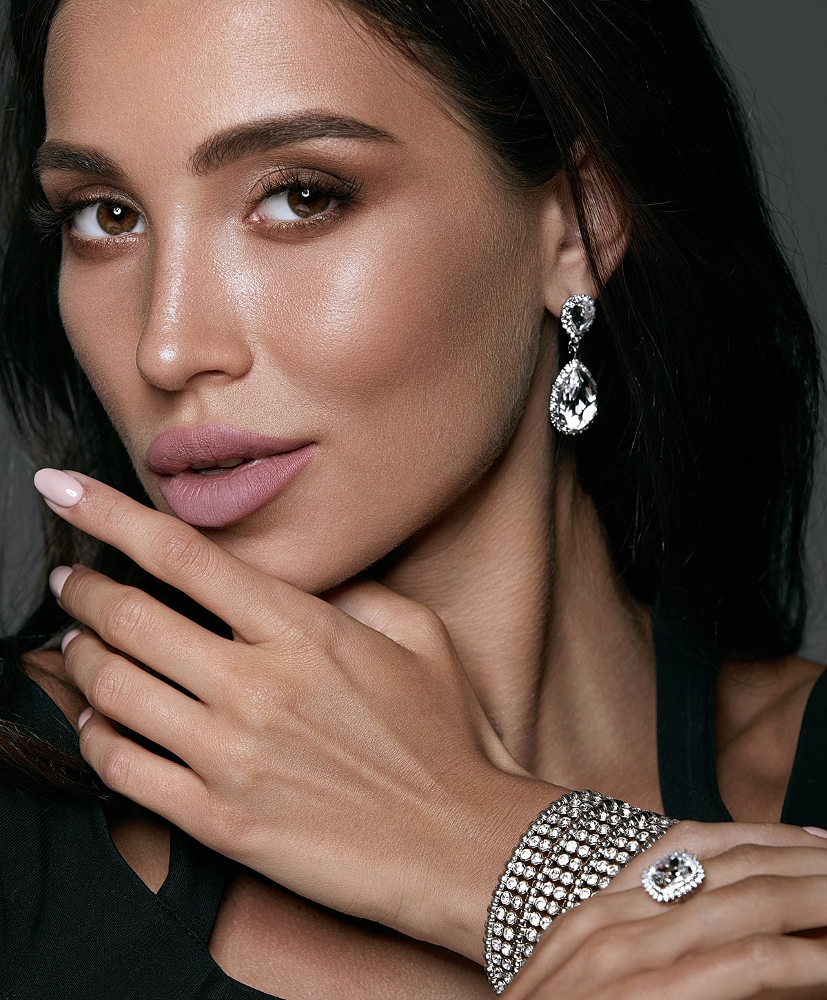 Woman with elegant earrings and bracelet.