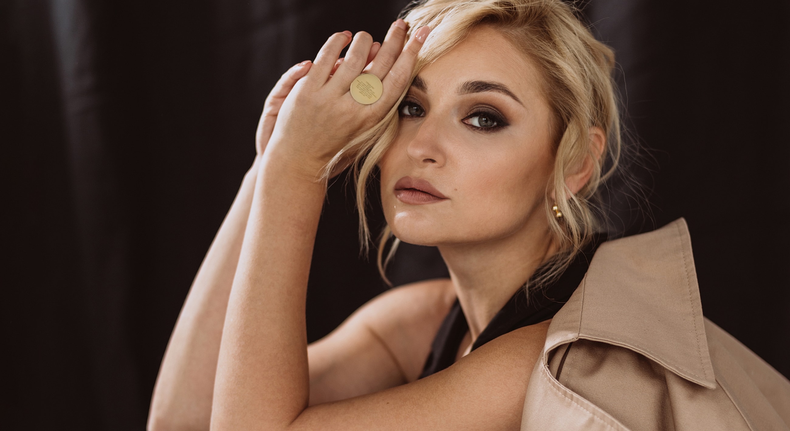 Woman posing with hand on face, stylish look.